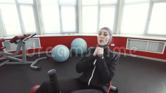 女运动员戴头巾坐着锻炼视频的预览图