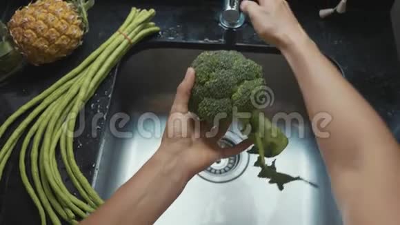 贴身女人她在家庭厨房慢动作地洗花椰菜视频的预览图