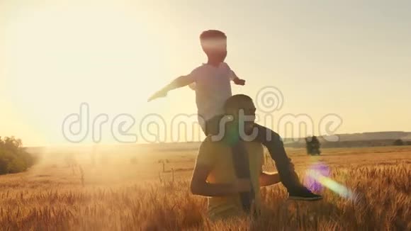 父亲把儿子扛在肩上日落时在麦田里散步家庭游戏视频的预览图
