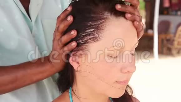 治疗师她的手对女人做头部按摩视频的预览图