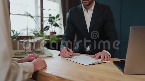 妇女签订抵押合同签订买卖租赁协议与房地产经纪人见面时握手视频的预览图