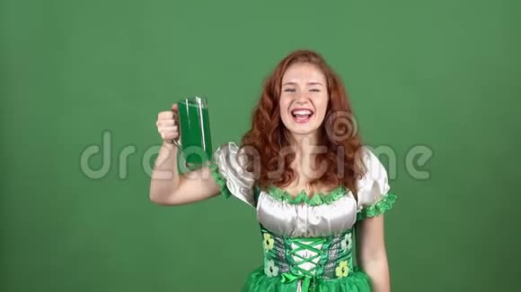 年轻女子在绿色的墙上庆祝圣帕特里克节穿着传统的衣服绿色的啤酒露出大拇指视频的预览图