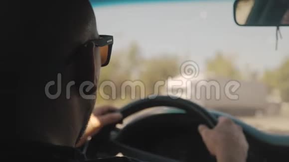 开车的年轻人坐在车里开车的人阳光明媚的天气旅行视频的预览图