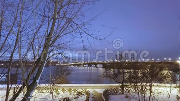 时光流逝在一个大雪纷飞的冬天阴天的傍晚日落可以看到第聂伯河和帕托纳桥路人视频的预览图