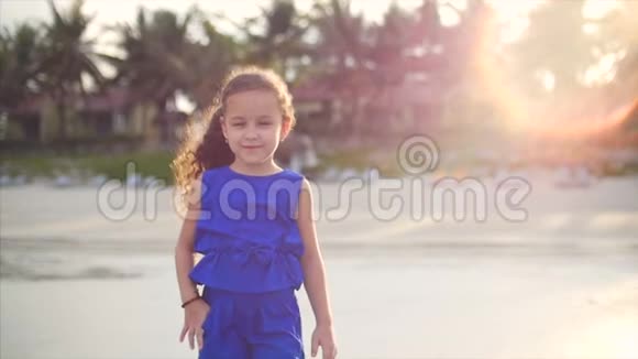 年轻快乐娇小的女孩走在海边穿着蓝色西装的快乐小女孩白种人走路视频的预览图