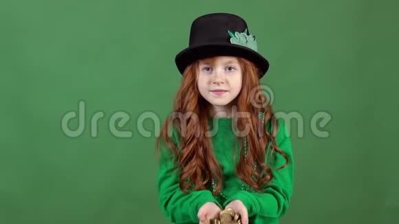 女孩红发庆祝圣帕特里克节绿墙背景站着扔金子视频的预览图