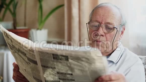 坐在椅子上看报纸的老人视频的预览图