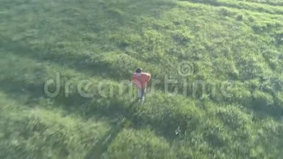 飞越运动男子跑在完美的绿色草地农村草地越野在山上日落原始的平色没有视频的预览图