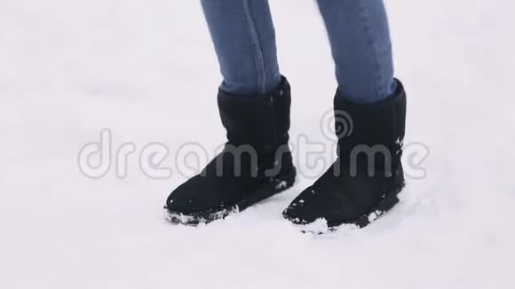 一个年轻女孩跳起来保暖的腿那个女人在一个白雪覆盖的冬季公园里冻僵了视频的预览图