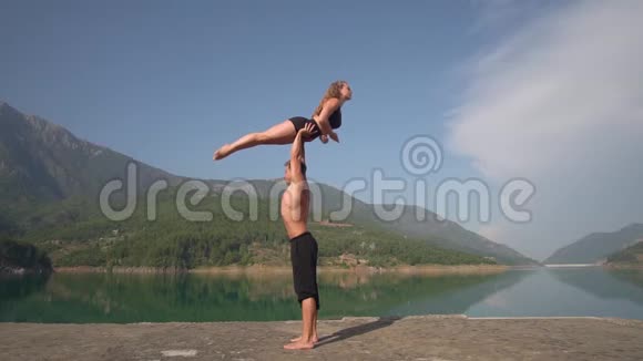 男人和女孩体操运动员在大自然的背景下表演一个魔术视频的预览图