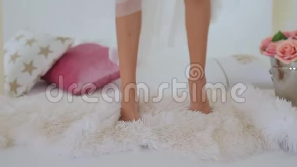 女孩的脚踩在白色的皮毛上视频的预览图