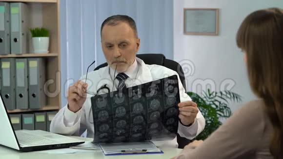 神经外科医生分析脑部x线并与病人谈论严重疾病视频的预览图
