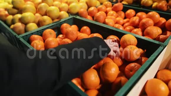 一个从有机农场挑选的超市里挑选新鲜橘子的年轻女人一位迷人的年轻人的双手特写视频的预览图