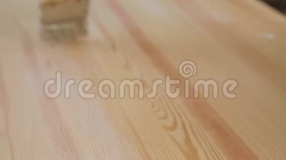 女人手里的刷子漆木桌视频的预览图