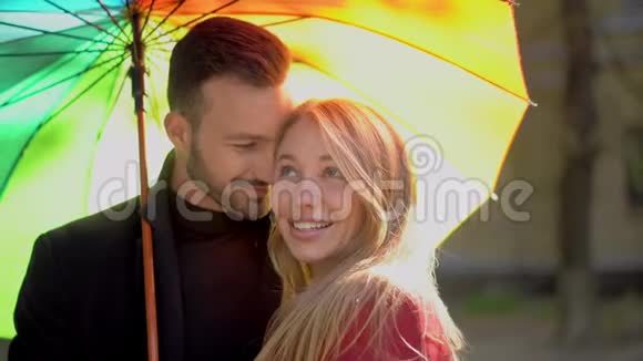 在彩虹伞下散步的情侣视频的预览图