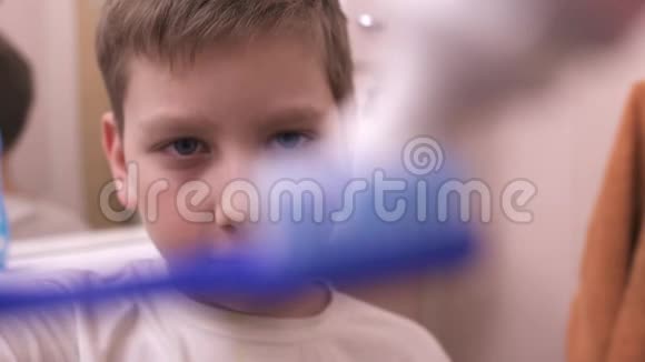 小男孩在牙刷和刷牙上挤牙膏视频的预览图