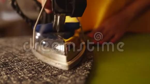 女裁缝工在裁缝车间用专业的铁蒸制羊毛服装女性手握视频的预览图