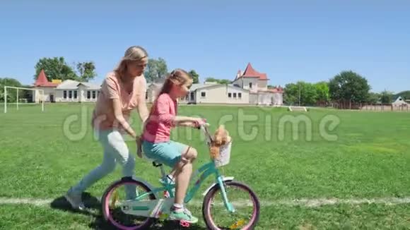 妈妈和女儿玩教她骑自行车视频的预览图