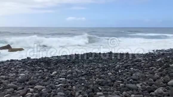 大卵石海滩和海浪到达海岸的时间间隔特内里费岛岩石海岸视频的预览图