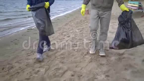 志愿者在海滩上搬运垃圾视频的预览图