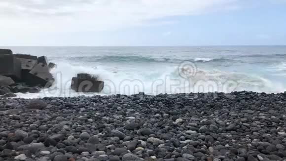 大卵石海滩和海浪到达海岸的时间间隔特内里费岛岩石海岸视频的预览图