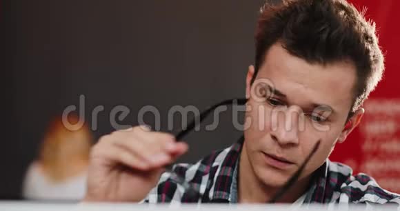 头痛的疲倦男子坐在办公室的笔记本电脑前视频的预览图