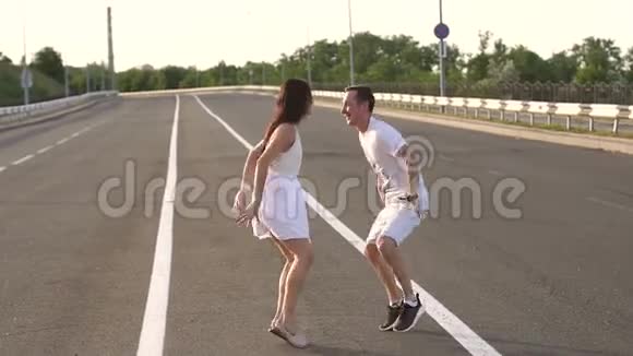 一对恋爱中的夫妇正在空跑道上跳舞慢动作视频的预览图