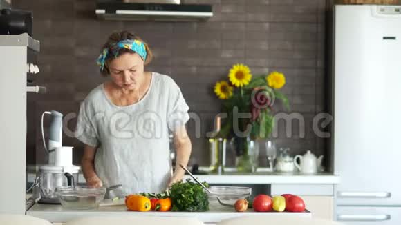 一位老妇人在家准备食物现代明亮的厨房内部素食适当的营养视频的预览图