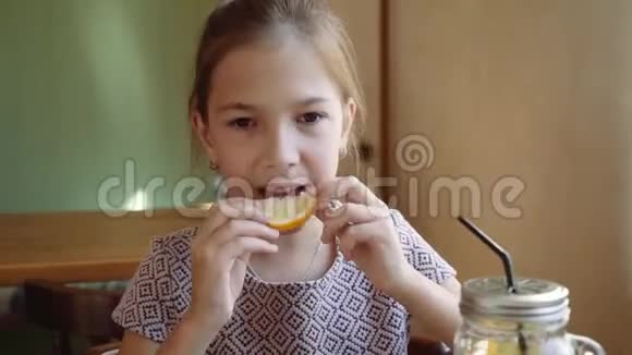 漂亮的年轻女孩吃一个柠檬脸上挂着鬼脸视频的预览图