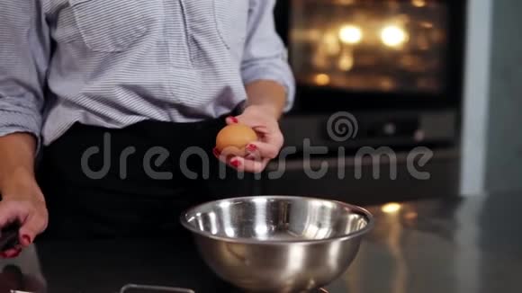 糕点糖果是分离白色和蛋黄特写她用刀子把它打碎然后把它放进钢碗里视频的预览图