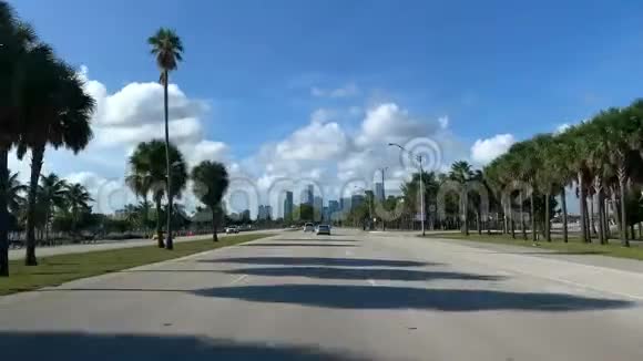 迈阿密摩天大楼和蓝天的阳光背景下有交通的公路视频的预览图