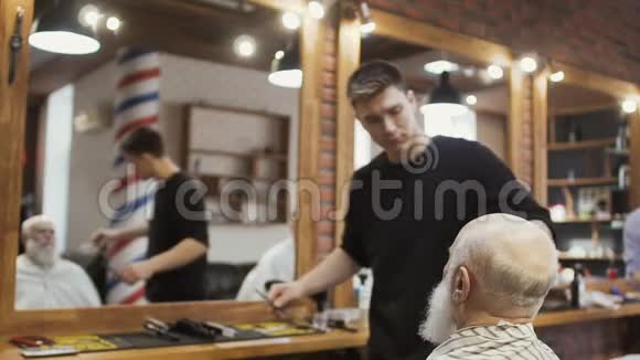 发型师梳着一个年长男人的灰色胡子视频的预览图