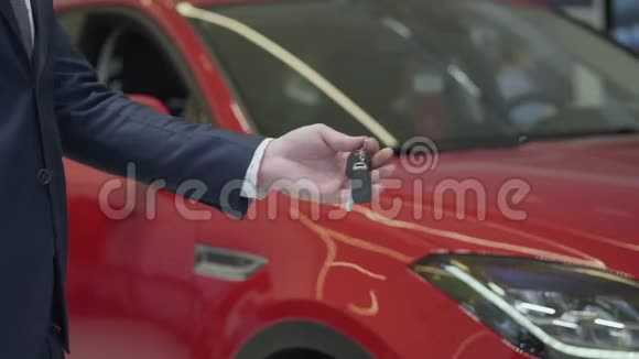 未识别的推销员给未识别的女商人一把汽车钥匙并在汽车经销商中握手汽车陈列室视频的预览图