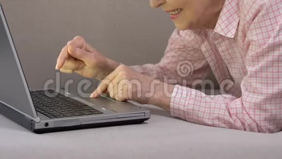 快乐的老年女性在笔记本电脑上打字在社交网络上聊天科技视频的预览图