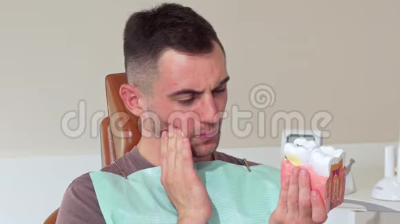年轻人牙疼坐在诊所的牙科椅上视频的预览图