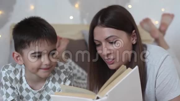 妈妈和儿子正在床上看书妈妈吻她儿子视频的预览图