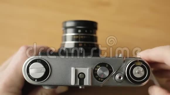 摄影师将旧胶片相机的胶片倒带按下按钮视频的预览图