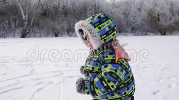 冬天一个可爱快乐的小男孩在公园里跑步视频的预览图
