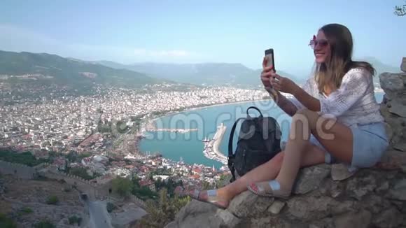 美丽的女孩在电话上拍照阿拉尼亚全景视频的预览图