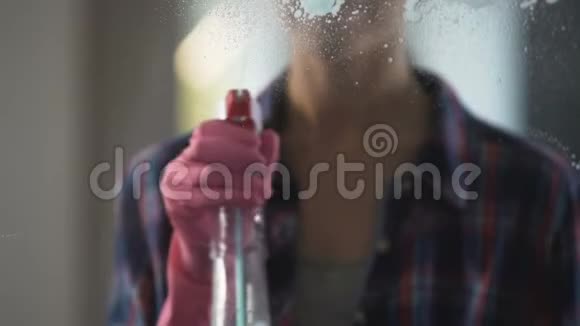 有经验的家庭主妇在窗户上喷洒大量的洗涤液来清洗它视频的预览图