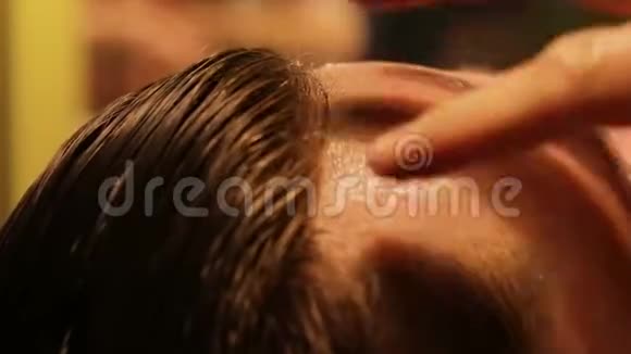 不可辨认的理发师在他的男模特写的脸上涂上了剃须凝胶视频的预览图