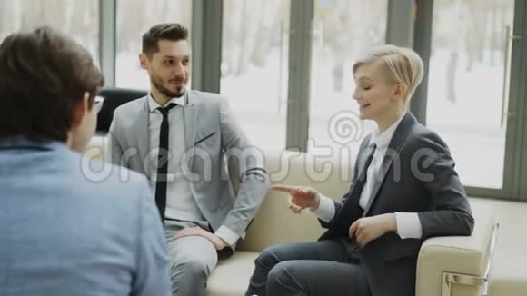 乐观的女商人与坐在上面的男性商业伙伴进行对话和模糊未来的协议视频的预览图