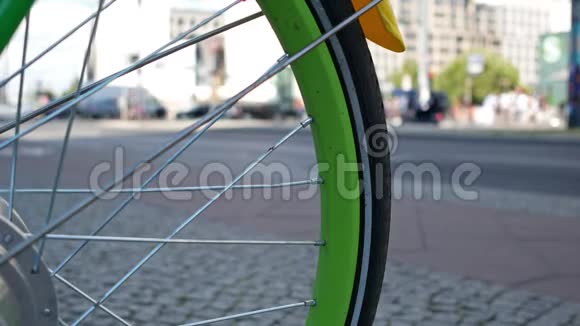 以交通为背景的自行车的绿色轮辐选定焦点视频的预览图