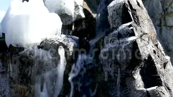 雪覆盖岩石上的小瀑布视频的预览图