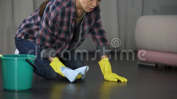 女人为擦得不好的地板和木木地板上的污渍而苦恼视频的预览图