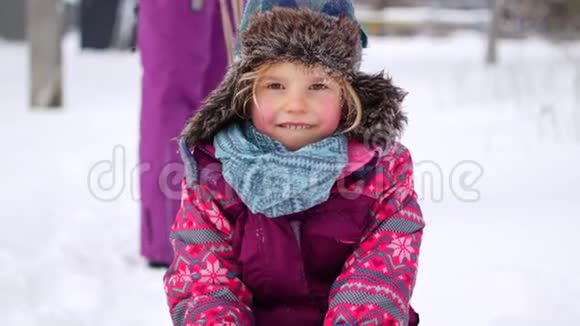 一家人在冬天的公园里散步有孩子的父母在雪橇上视频的预览图