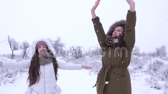 冬天休闲笑的女孩在雪下玩得开心视频的预览图