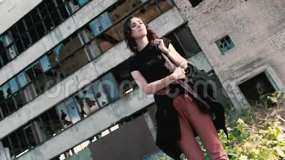 一个年轻的女人站在一座废弃的建筑旁想知道她在哪里视频的预览图