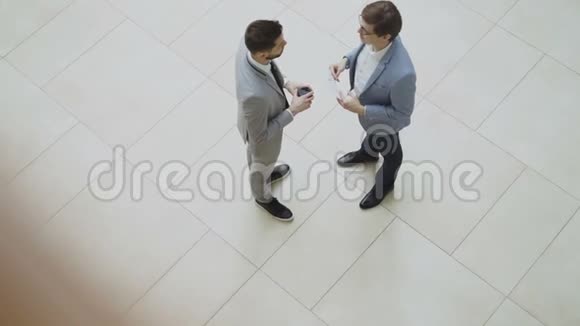 两位商人讨论财务报告时的最大视角然后告别握手在大厅里走开视频的预览图
