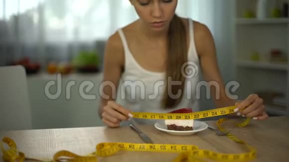 女孩用胶带测量蛋糕害怕体重增加食物限制视频的预览图